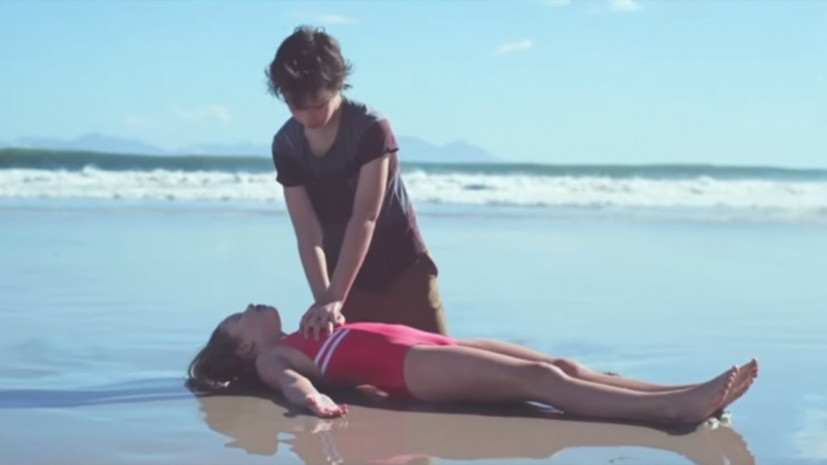 Мужик спасает девушку. Парень спасает девушку из воды. Искусственное дыхание девушке. Искусственное дыхание на пляже.